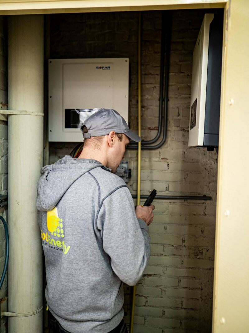 Photo by Stefan de Vries A technician examines solar power installations indoors, ensuring optimal performance.