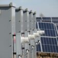 Close-up of electrical boxes and solar panels harnessing solar energy outdoors.