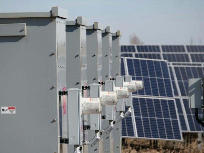 Close-up of electrical boxes and solar panels harnessing solar energy outdoors.
